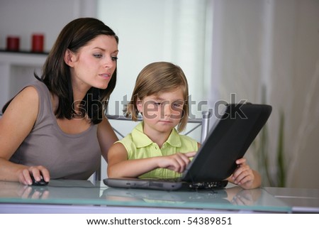 Portrait of woman and a little girl in front of a laptop computer