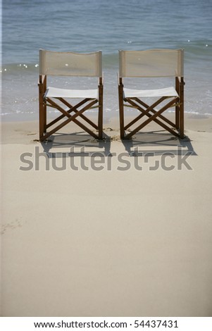 Folding chairs on the sand at the edge of the sea