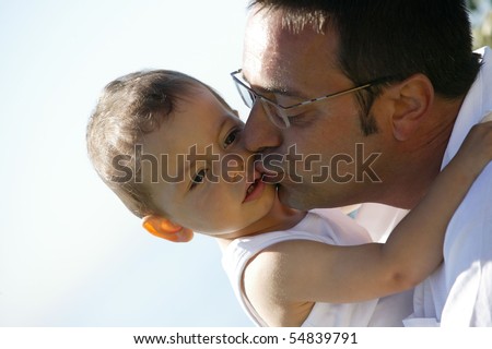 Portrait of a man kissing a little boy on the cheek