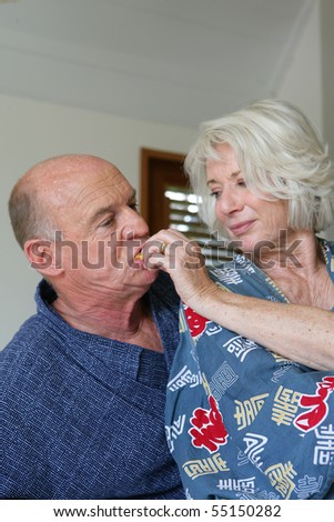 Senior couple in dressing gown having breakfast