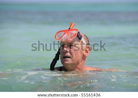 Portrait of a senior man in the sea with a snorkel and goggles