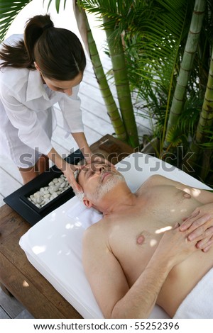 Portrait of a senior man being massaged by a young woman