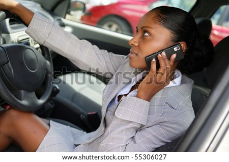 Portrait of a young woman in suit phoning in a car