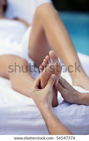 Laid woman being massaged the sole of the foot