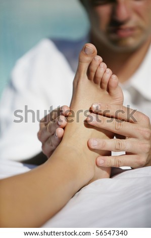 Man massaging the sole of the foot of a woman