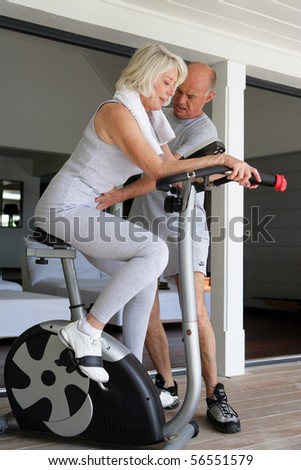 Sports Coach caring for an elderly woman sitting on a bike