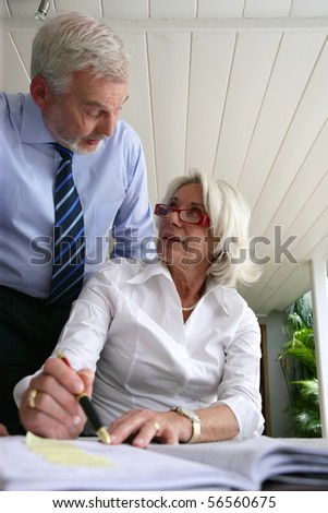Senior couple in suit planning a meeting on a diary