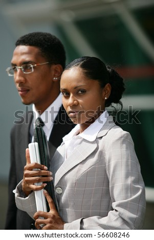 Portrait of a young man and a young woman in suit holding documents