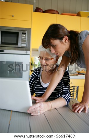 Portrait of a young woman and a senior woman in front of a laptop computer