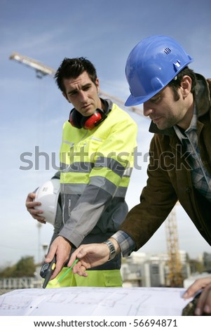Two workers reading a plan