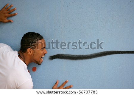 Young man with mouth open face to a graffiti