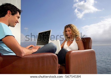 Young man and young woman with laptop computers sitting face to face