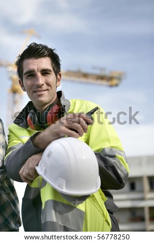 Portrait of a young man with safety vest and noise-canceling headphones