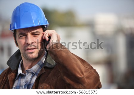 Portrait of a man with safety helmet and a mobile phone