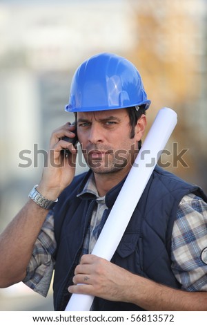 Portrait of a man with safety helmet and a mobile phone
