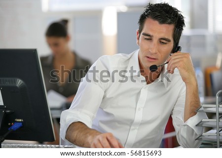 Portrait of a man sitting at a desk with a headset