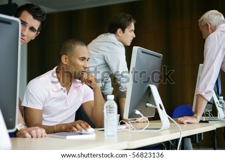 Portrait of a young man sitting in front of a desktop computer