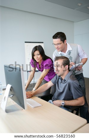Young woman and young men in front of a desktop computer