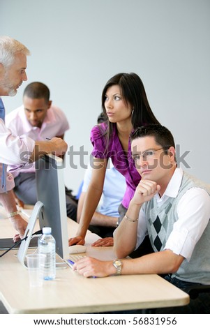 Portrait of men and a young woman in front of a desktop computer