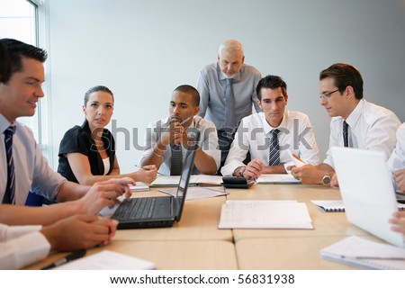 Portrait of business people in suit in a meeting room with laptop computers