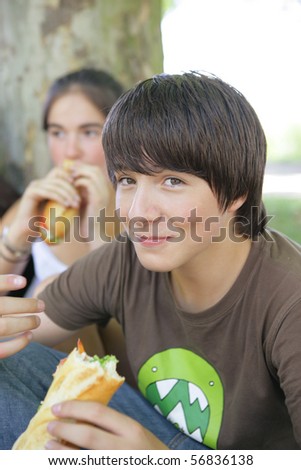Portrait of a smiling boy eating sandwiches