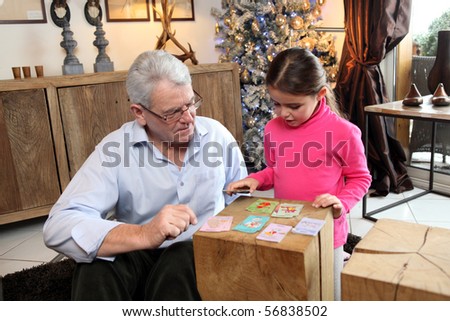 Senior man playing cards with little girl