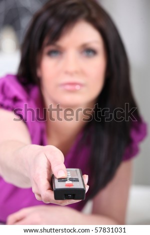 Portrait of a woman with a tv remote