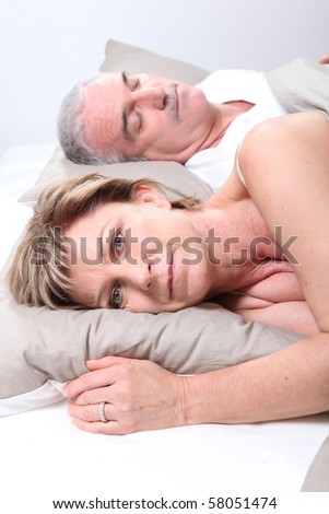 Senior couple laid in a bed