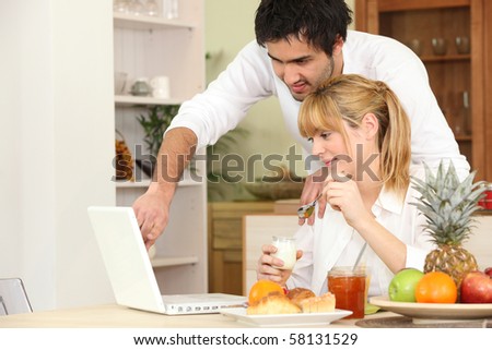 Couple having breakfast in front of a laptop computer