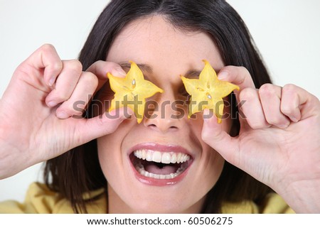 Portrait of a woman playing with slices of star fruit