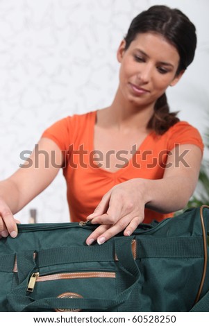 Young woman preparing travel bag