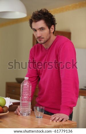 Man with bottle of water in the kitchen