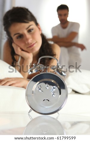Laid woman watching the alarm clock