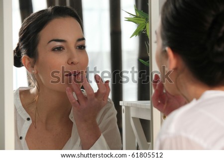 Portrait of a woman making up her lips