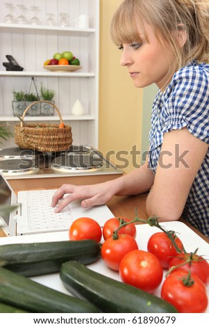 Young woman in front of computer in the kitchen