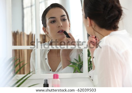 Portrait of a woman making up her lips