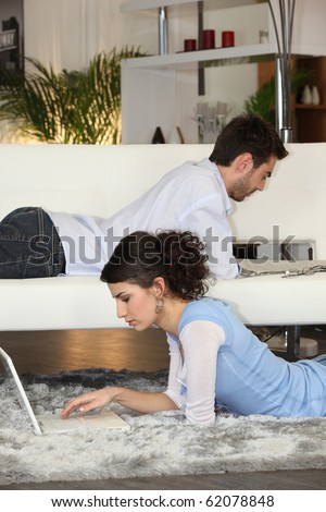 Couple relaxing in front of laptop computer