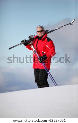 Senior man with skis in snow