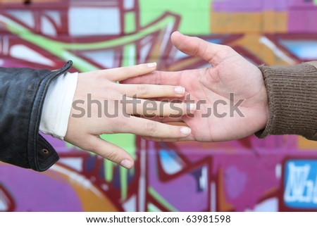 Hands in front of graffiti wall