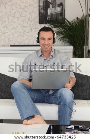 Man with headphones in front of a laptop