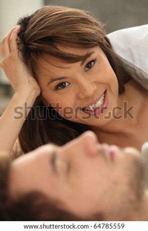 Smiling woman next to a sleeping man