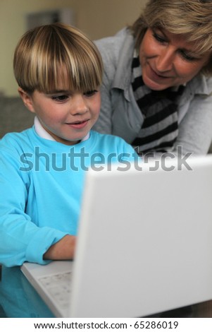 Senior woman and boy in front of laptop computer