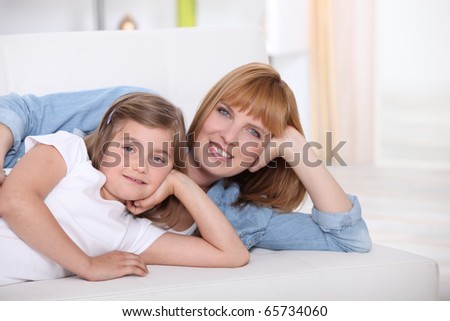 Woman and girl laid on a sofa