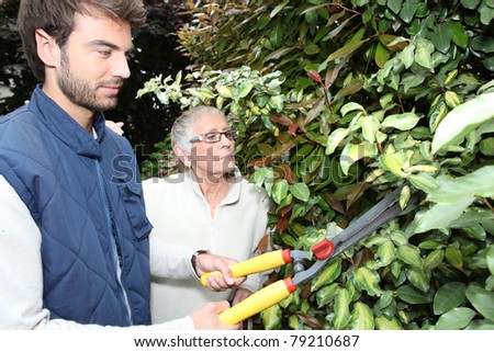 young man gardening with older woman