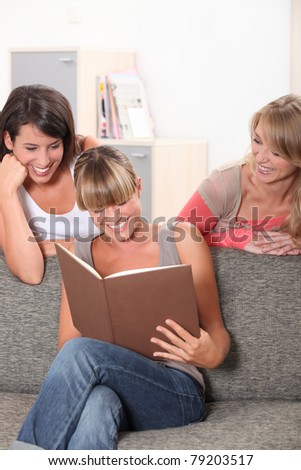Girls laughing at book