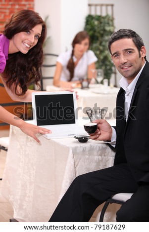 Couple looking at a blank computer screen in a restaurant