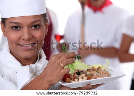 young chief cook showing a salad dish