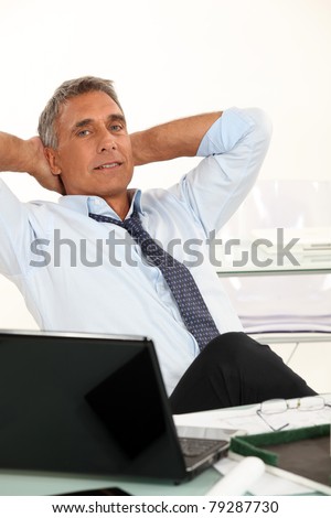 50-55 years old man dressed in shirt and tie is relaxing in his office
