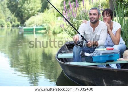 Couple fishing in a small boat on a river