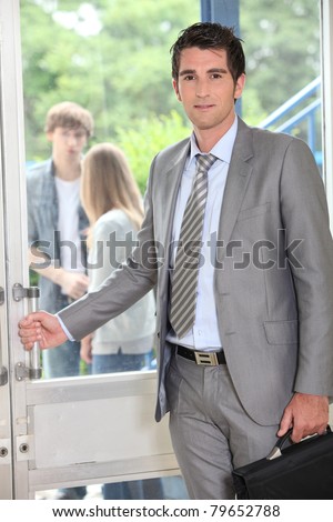 Teacher carrying briefcase opening door